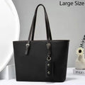 Black handbag with a strap on a light gray background