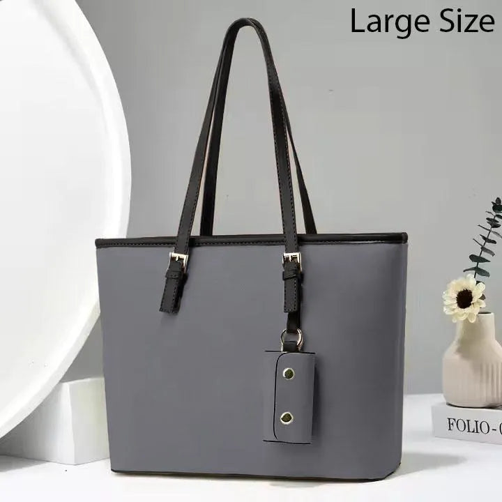 Gray handbag with black straps on a light gray background